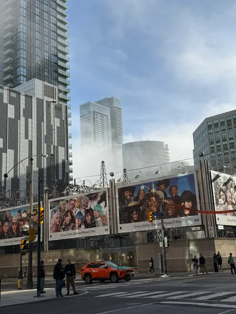 Pedestrians pass a mural and high-rise buildings in downtown Toronto.