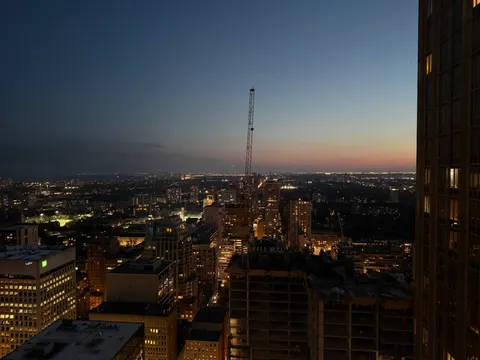 Toronto's CN Tower punctuates a broad city panorama at dusk.