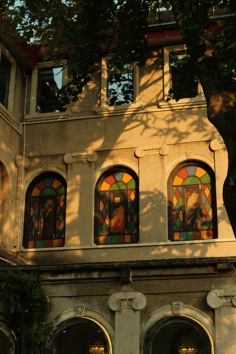 Arched windows glow in warm afternoon light on a historic facade.