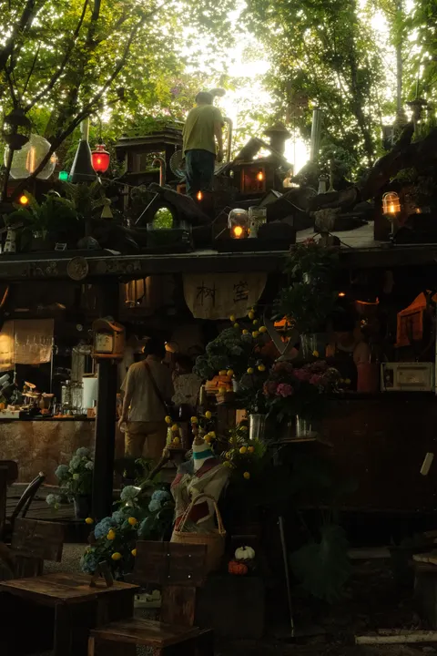 A crowded indoor market is packed with hanging decorations and signs.