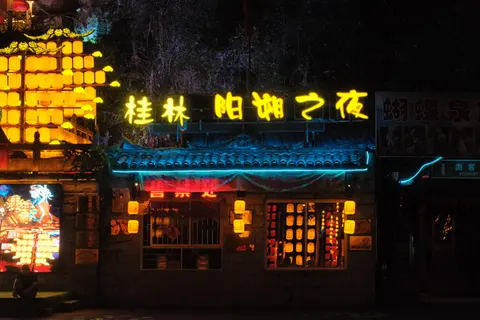 Neon Chinese signs illuminate a restaurant frontage in Guilin.