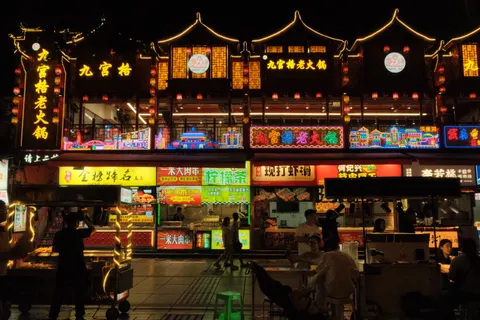 A traditional-style Chongqing facade blazes with colorful signs at night.