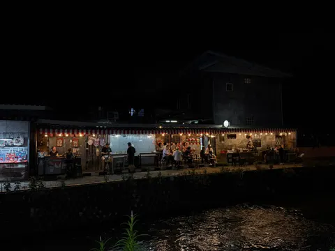 A long illuminated mural stretches across a dark Chiang Mai wall.