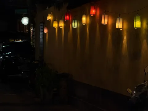 Small amber lights wash a dark stucco wall in Chiang Mai.