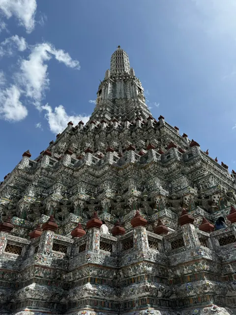 An ornate stone temple spire rises against a bright blue sky.