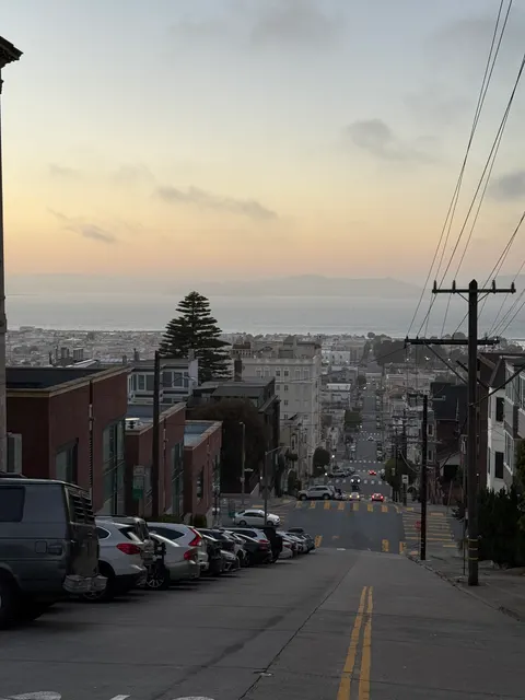 Utility wires cross above a steep residential street in San Francisco.
