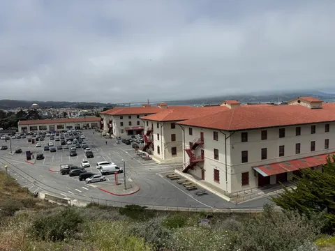 A red-roofed institutional complex overlooks San Francisco.